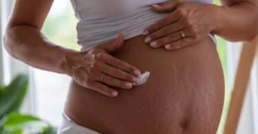 pregnant belly applying cream