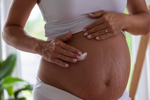 pregnant belly applying cream