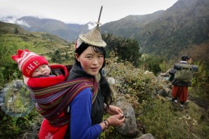 A mom hikes with her baby in Laya, North West Bhutan