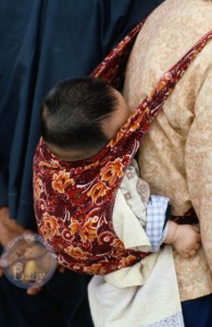 A little baby fast asleep on mom's back