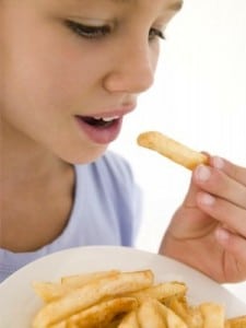 Child Eating A Plate Of French Fries