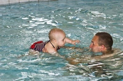 baby swimming with dad