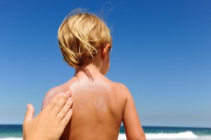 mother applying sunscreen on child´s back