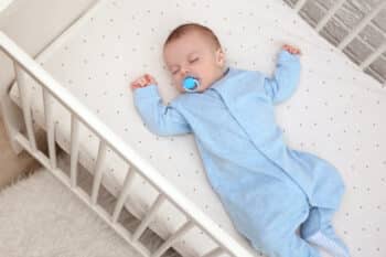 Cute little baby sleeping in cradle at home