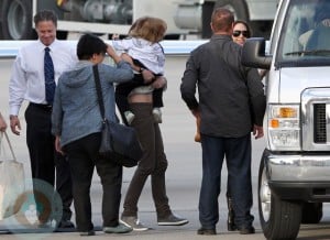 Knox Jolie PItt being carried by an assistant