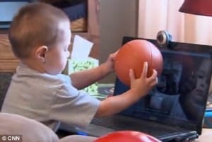 Seth shows his father his basketball as he plays during one Skype conversation