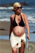 A pregnant Tori Spelling at the beach