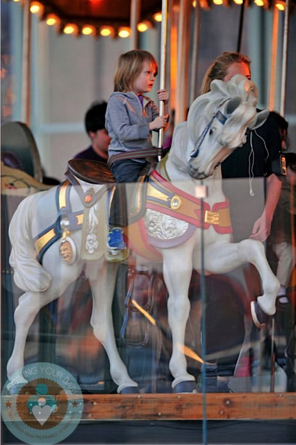 River Deary rides the carousel in Brooklyn