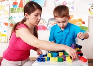 teacher and child stacking blocks