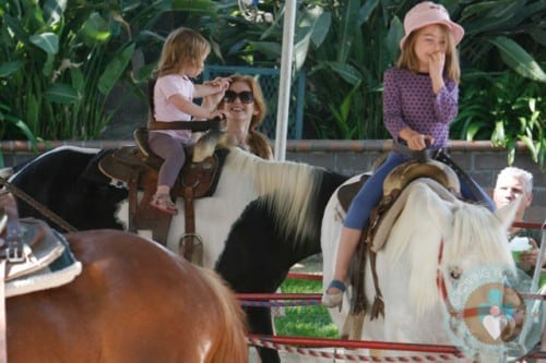 Isla Fisher with daughters Elula and Olive riding the ponies