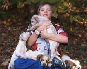 Kyle Camp surrounded by puppies