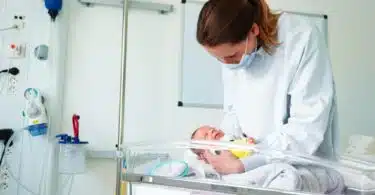 nurse holding premature baby in NICU
