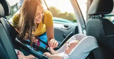mom putting baby in car seat
