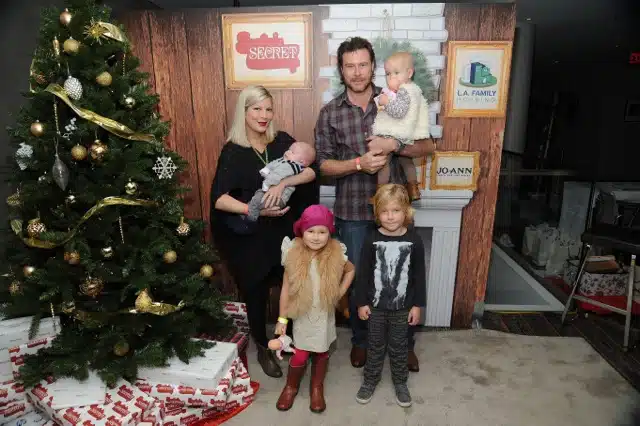 Tori Spelling, Dean McDermott, and Liam, Stella, Hattie and Finn pose by the Xmas tree