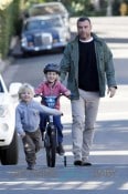 Liev Schreiber and little Samuel cheer on Alexander as he tests out his training wheels in Los Angeles