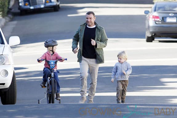 Liev Schreiber and little Samuel cheer on Alexander as he tests out his training wheels in Los Angeles