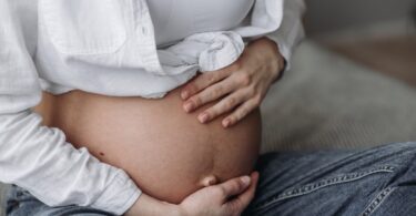 woman cradles her pregnant belly