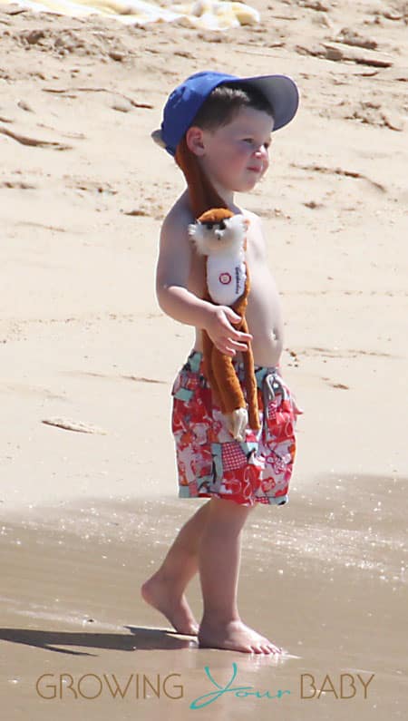 Coleen Rooneys' son Kai sports a monkey attached to his hat while at the beach.