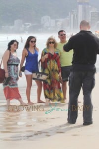 Fergie, wearing a bright, draping dress, visits Ipanema beach with her entourage in Rio De Janerio