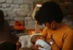 Mom breastfeeds newborn baby at home