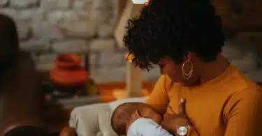 Mom breastfeeds newborn baby at home