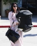 Kourtney Kardashian leaves a dance class carry an Orbit Baby Car seat