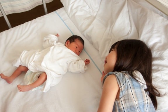 little girl meeting sibling