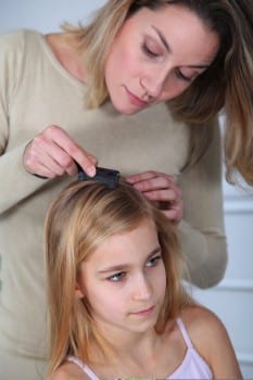 mom checks daughters hair for lice