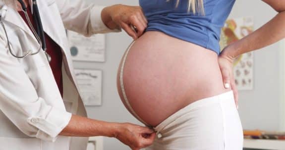  Doctor measuring pregnant woman's belly 