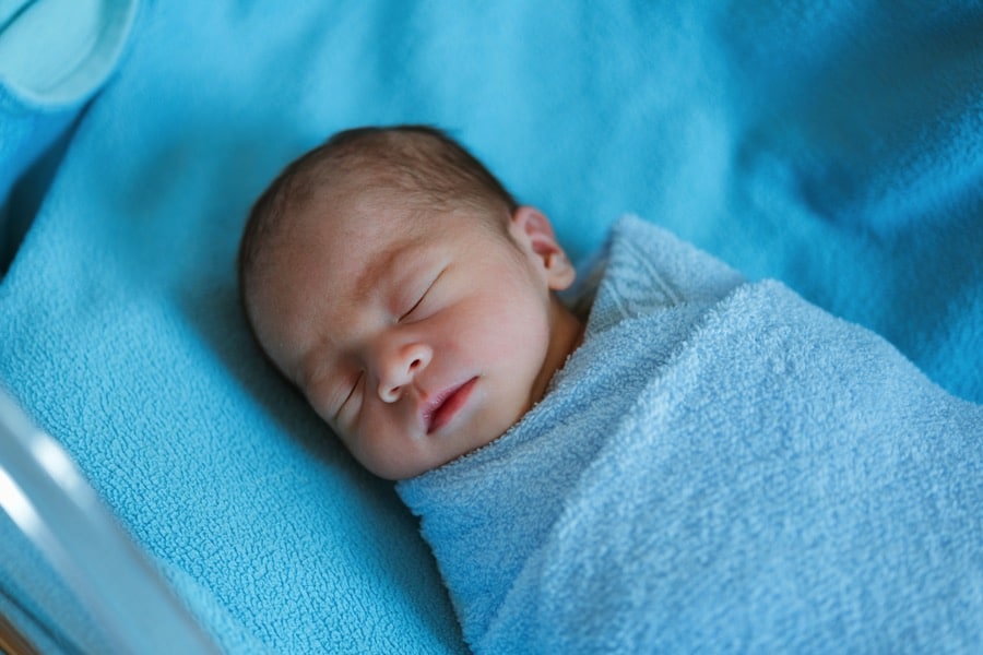 Newborn baby sleeping covered with blue cloth