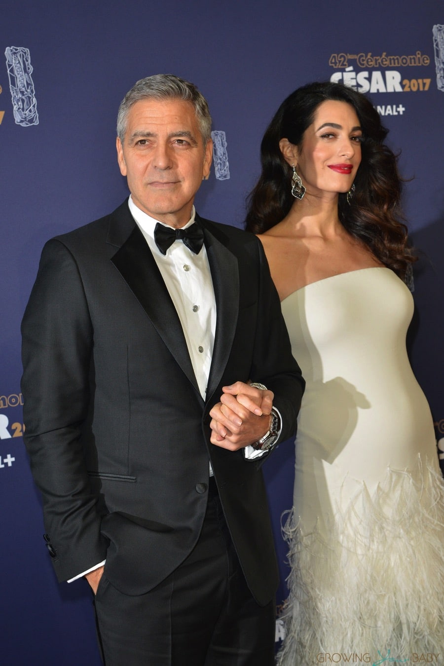 George Clooney and a pregnant Amal Clooney attend the photocall for Caesar's Film awards looking elegant together.