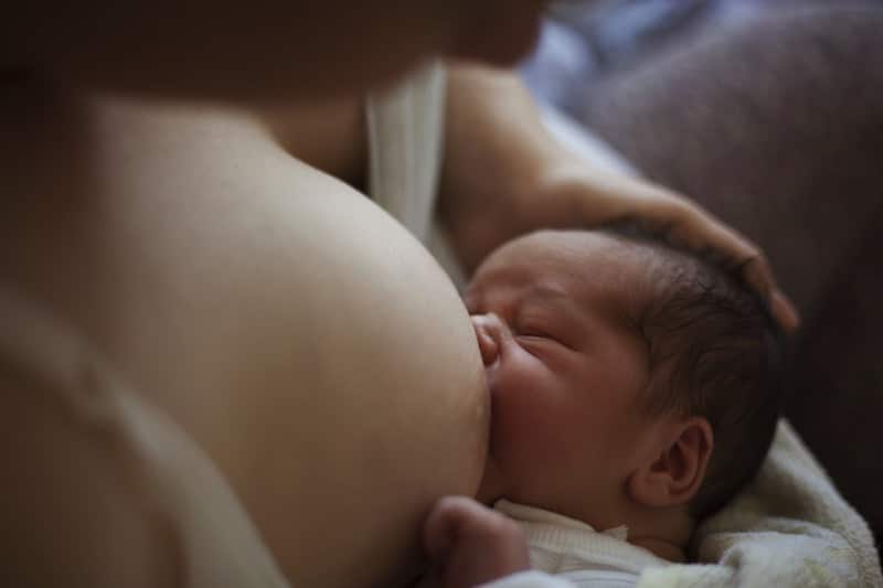 Newborn baby drinking from breast