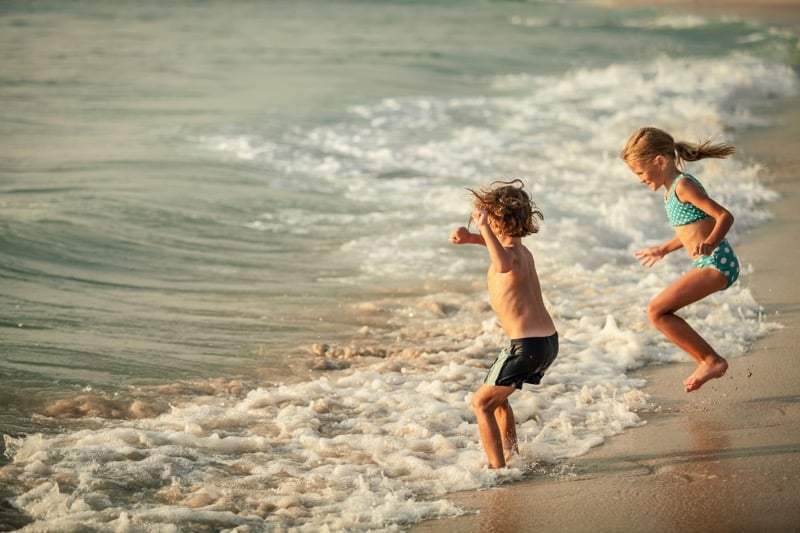 Two happy children playing on the beach