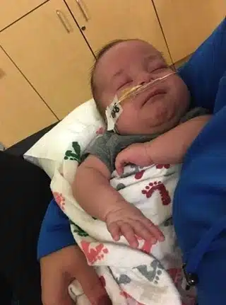 Officer Jordan Buschman cuddles with baby Axel.