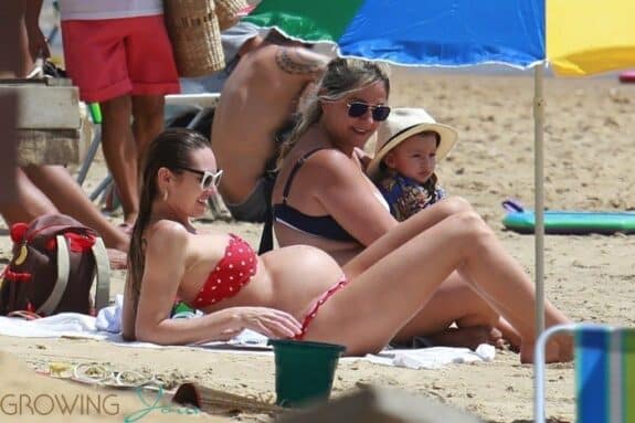 Candice Swanepoel shows off her very large baby bump at the beach.