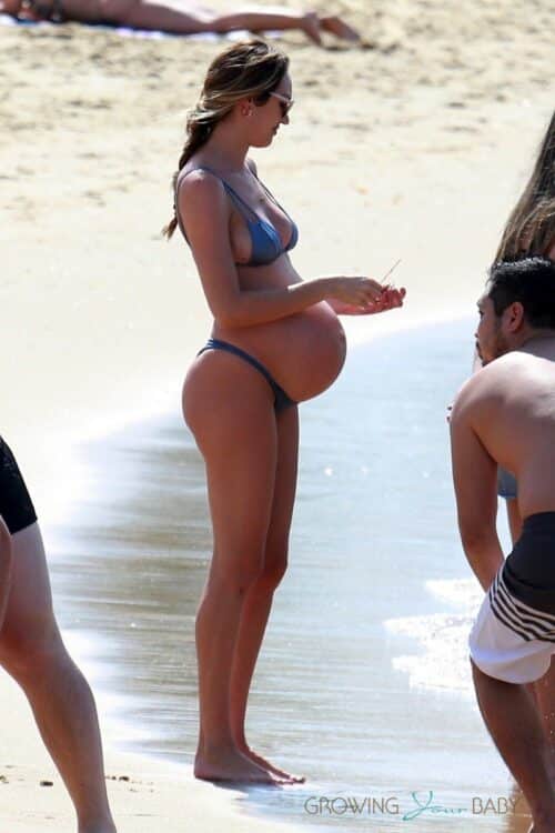 Candice Swanepoel looks like she's ready to pop as she enjoys a day at the beach