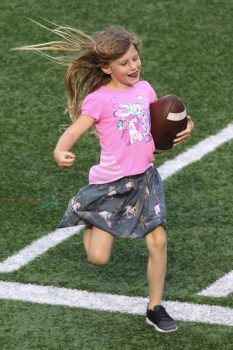 Vivian Brady running the ball at dad Tom Brady's Best Buddies Charity Event