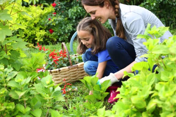 Little girl helping her mother to do gardening