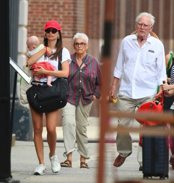 Emily Ratajkowski carries baby Sly as she arrives home with husband Sebastian and his parents