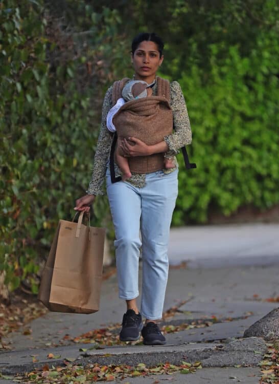 Freida Pinto with new son in a Artipoppe Zeitgeist Marron baby carrier