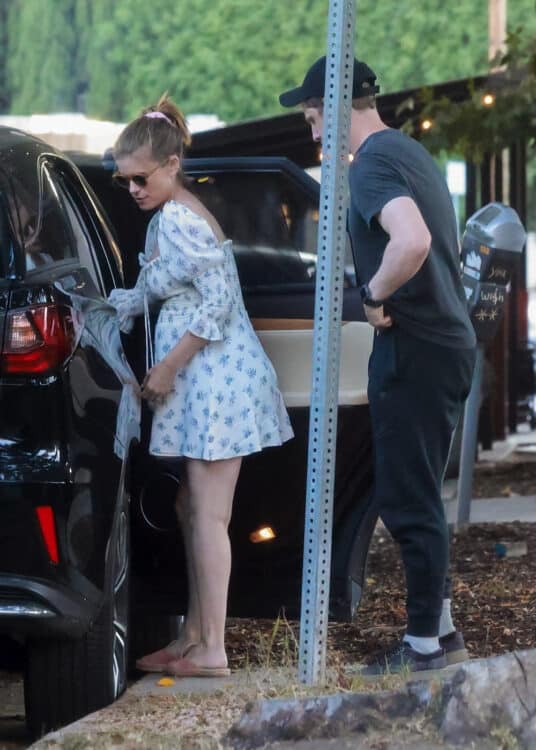 pregnant woman with toddler and husband beside car