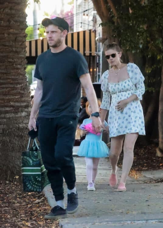 pregnant woman with toddler and husband walking to  the car