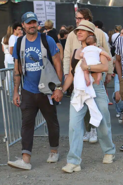 two parents walk at the fair holding their baby