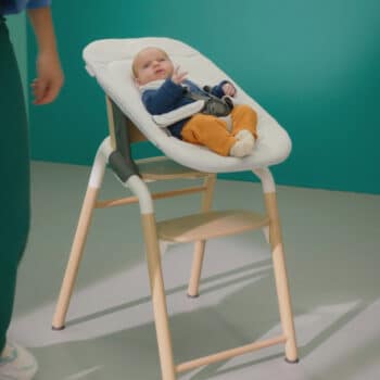 baby sitting in a seat that is elevated from the ground