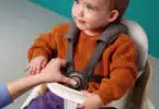 baby sitting in a seat that is elevated from the ground