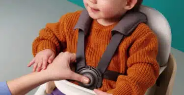 baby sitting in a seat that is elevated from the ground