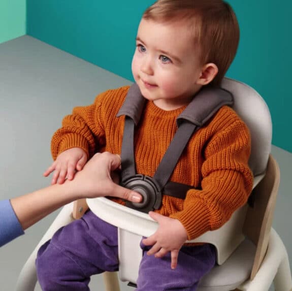 baby sitting in a seat that is elevated from the ground