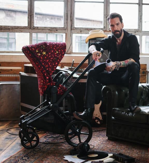 man sitting in his living room with a stroller