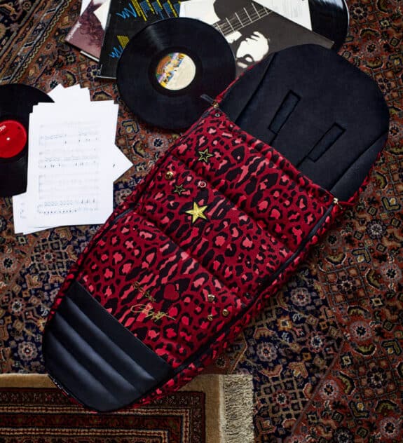 red patterened foot muff laying on the floor next to records.