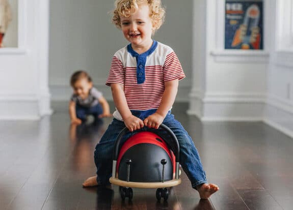 Child riding the Prince Lionheart Wheely Bug in the hallway